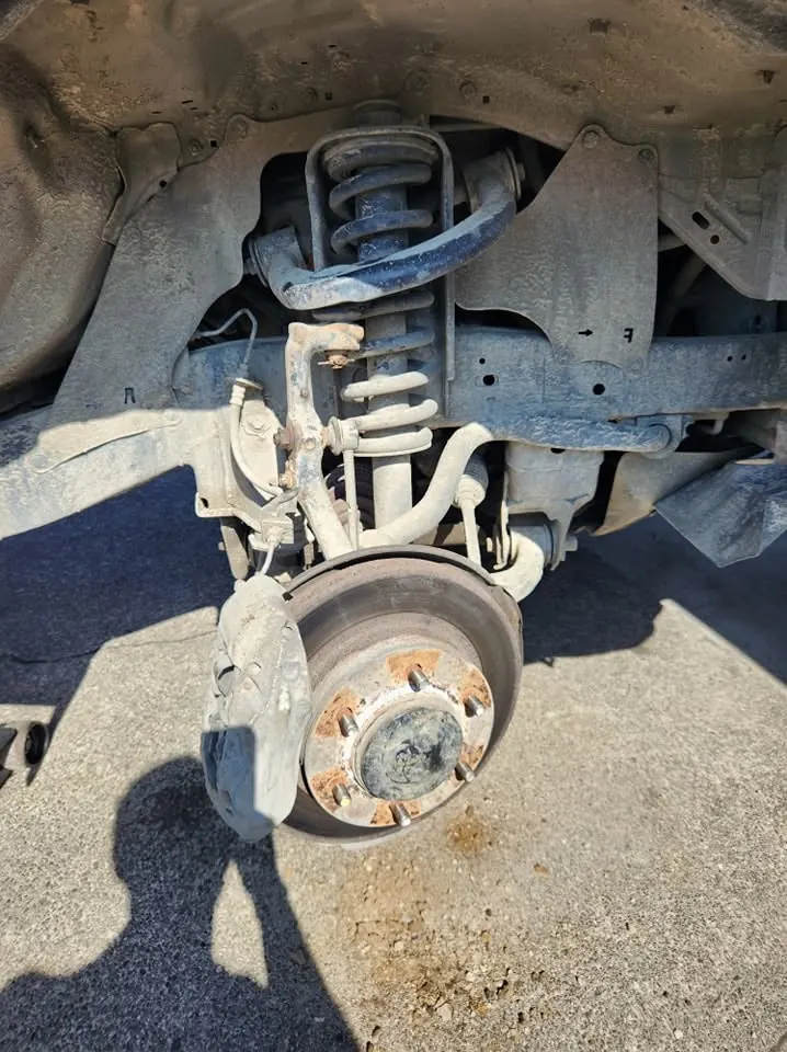 Close-up of front suspension and brake hub with the wheel off
